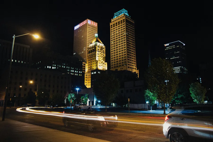 Downtown Tulsa at night, with the lit-up Philtower and car light trails